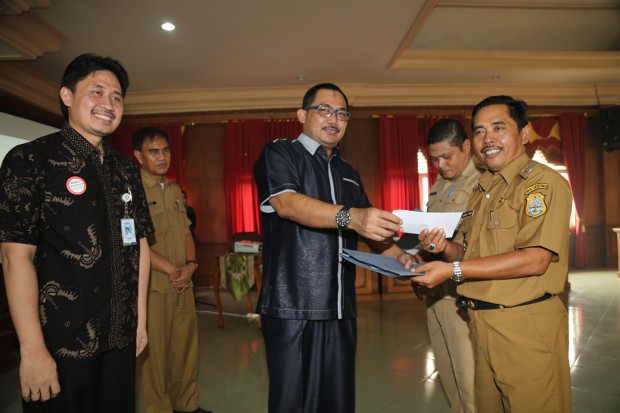 Sekretaris Daerah Tanjung Jabung Timur Sudirman menyerahkan secara simbolis Kartu Indonesia Sehat (KIS) kepada Camat Sadu